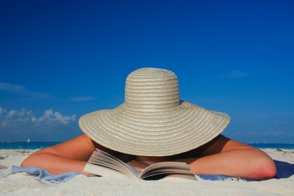 Person on a beach with a sun hat on